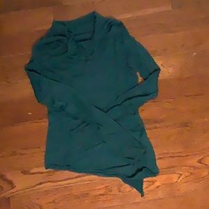 Green drapey turtleneck with asymmetrical hem.